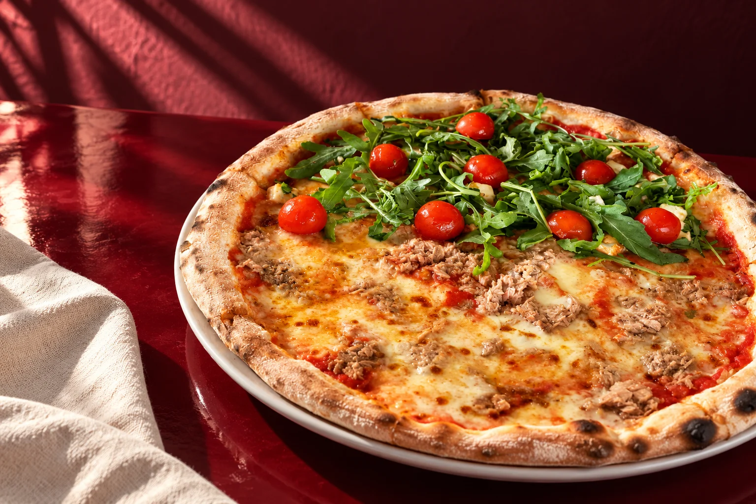 Pizza mit Rucola, Tomaten und Thunfisch, neu inszeniert